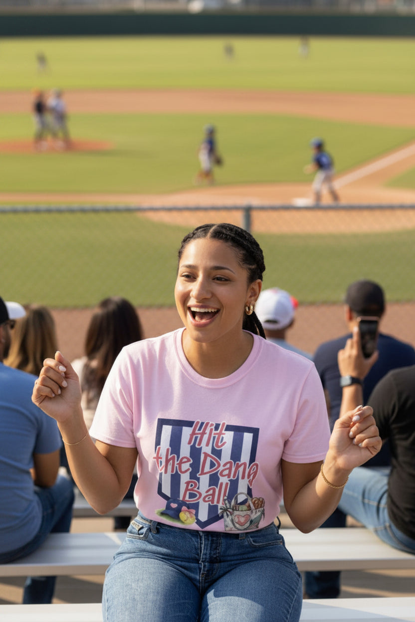 Woman in a pink t-shirt cheering at a baseball game